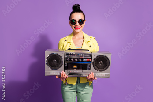 Photo of positive youth girl hold boom box wear green pants isolated over violet color background