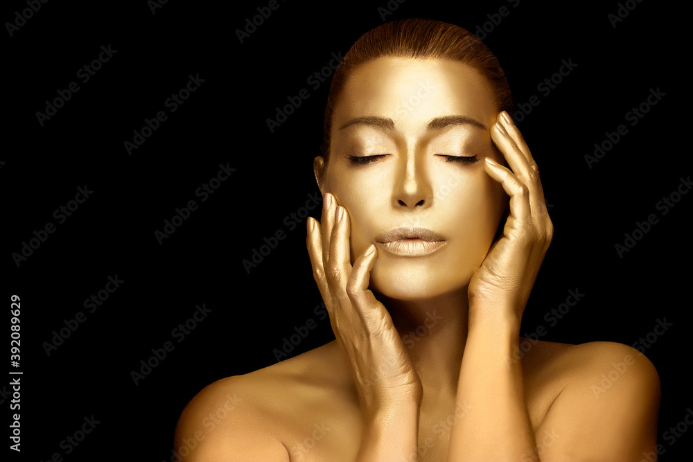 Gold skin woman. Beautiful model girl with glowing gold body makeup