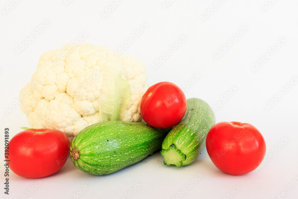 Various raw vegetables with water splash. Cauliflower, tomato, cucumber, radish and paprika on a green background. Various raw vegetables with water splash. Cauliflower, tomato, cucumber, radish and paprika on a green background.