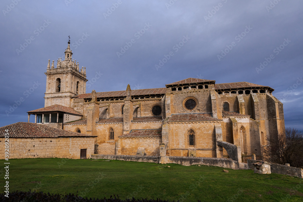 old gothic style catholic church lateral view with a dramatic sky in palencia, spain