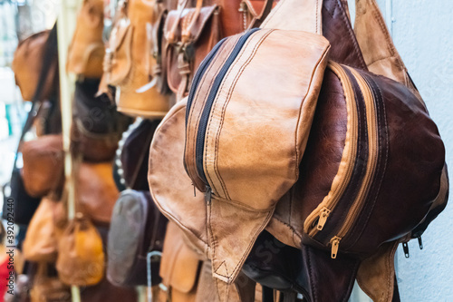 Close-up view of brown leather fanny packs with unfocused background