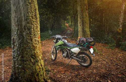 Adventure traveling enduro motocycle in mountain forest.