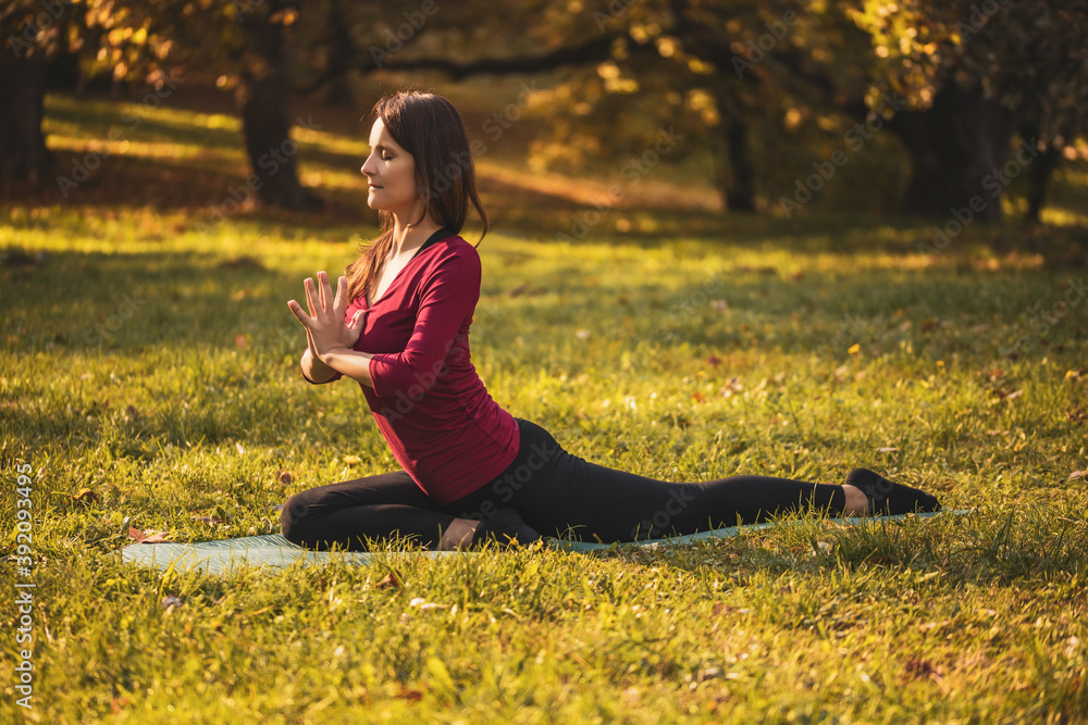 Beautiful woman doing yoga in the nature,variation of Eka pada Rajakapotasana/Pigeon pose variation Beautiful woman doing yoga in the nature,variation of Eka pada Rajakapotasana/Pigeon pose variation