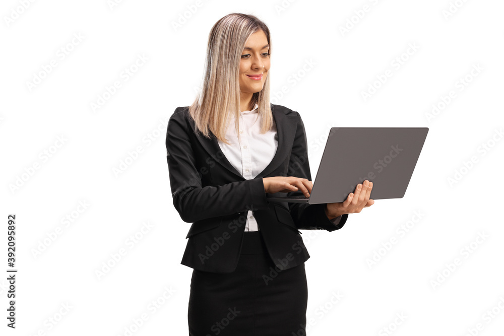 Young professional woman standing and working on a laptop computer Young professional woman standing and working on a laptop computer