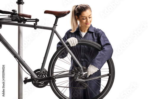 Female bike mechanic repairing a bicycle with a wrench