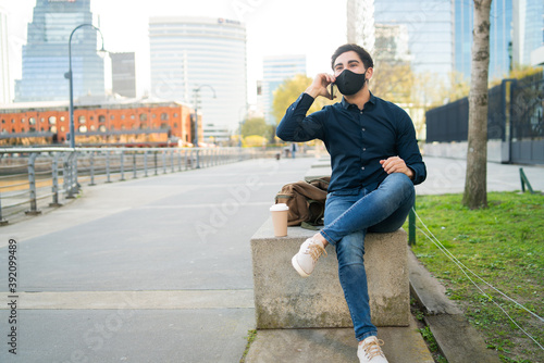 Young man talking on the phone outdoors.