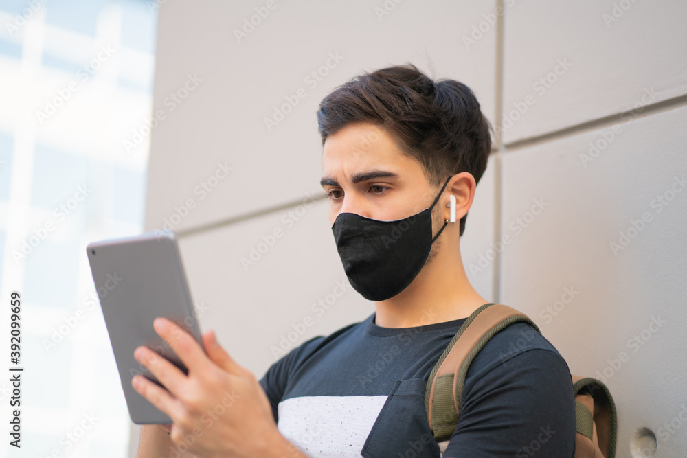 Young man using digital tablet outdoors. Young man using digital tablet outdoors.