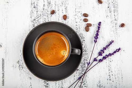 Double espresso. Close up espresso glass cup with coffee bean, on old wooden table photo