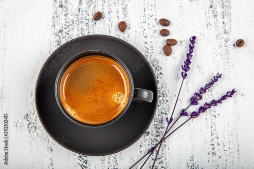 Double espresso. Close up espresso glass cup with coffee bean, on old wooden table photo