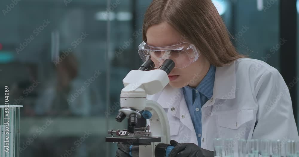 forensic expert is testing evidence in laboratory, viewing samples in microscope, female technician is researching analysis forensic expert is testing evidence in laboratory, viewing samples in microscope, female technician is researching analysis