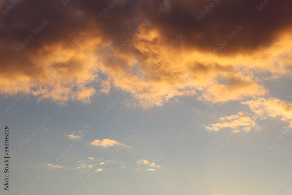 water-laden golden clouds with cotton texture over a clear blue and yellow sky in the background during the sunset - beautiful blank and simple wallpaper