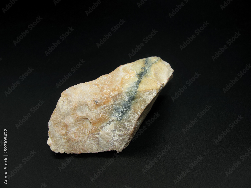 Sample of beige flint stone on a black background Sample of beige flint stone on a black background