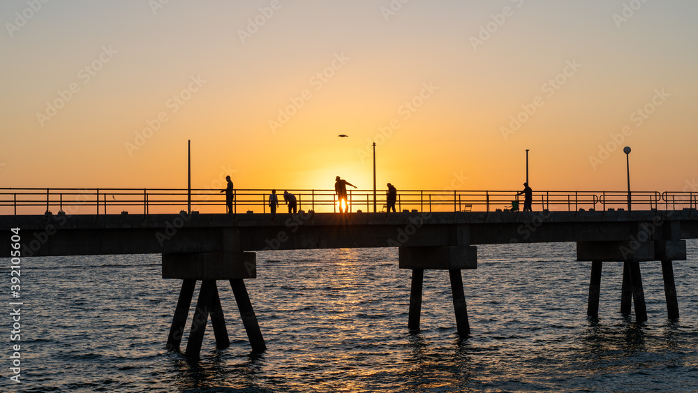 Pier with fishermen at sunset on Masirah Island in Oman Pier with fishermen at sunset on Masirah Island in Oman