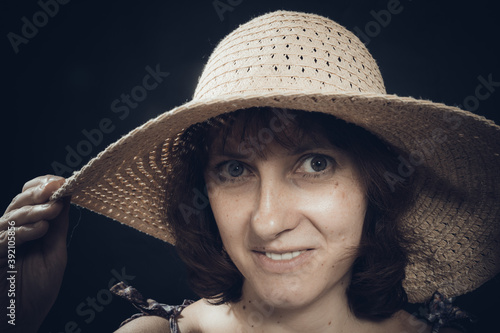 Cheerful 40 years old woman in wide-brimmed hat close up view