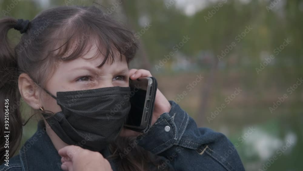 Masked child with telephone. A stressed little girl in medical mask scream on telephone in medical mask. Masked child with telephone. A stressed little girl in medical mask scream on telephone in medical mask.