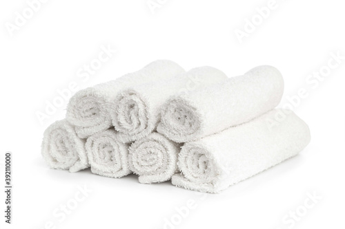 stack of white clean towels rolled up on white background