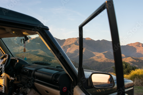 Black 4x4 car on the peak of the hill with mountains on background.
concept, car trip through nature.
Marbella, Malaga, Andalusia, Spain.