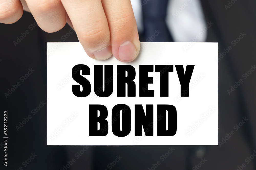 Businessman shows a card with the text SURETY BOND Businessman shows a card with the text SURETY BOND
