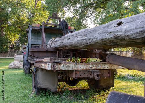 Old Logging truck with wooden logs on old traditional farm area. Abandoned car  Selective focus.