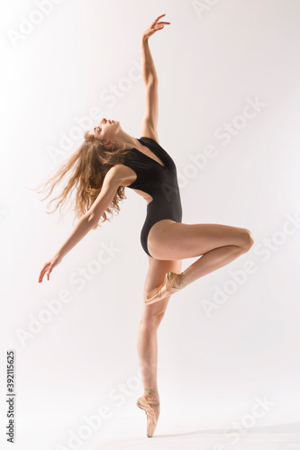 Ballerina in black leotard, dancing against a white background.
