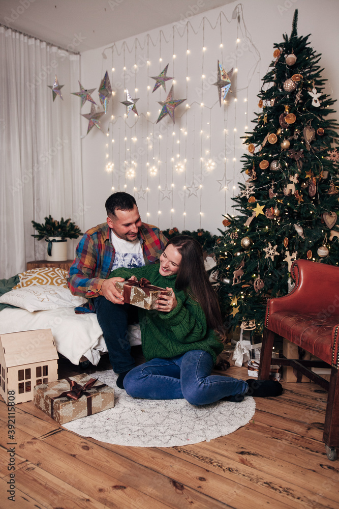 Fototapeta premium lovers hugging near the christmas tree