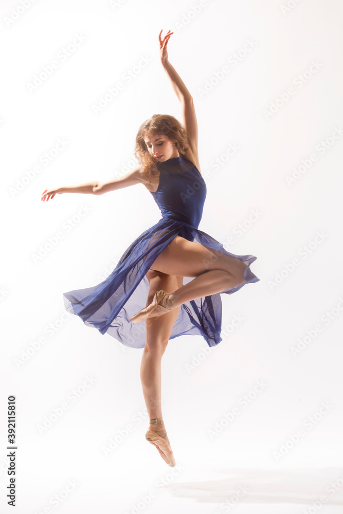 Ballerina in blue skirt dancing against white background. Stock Photo