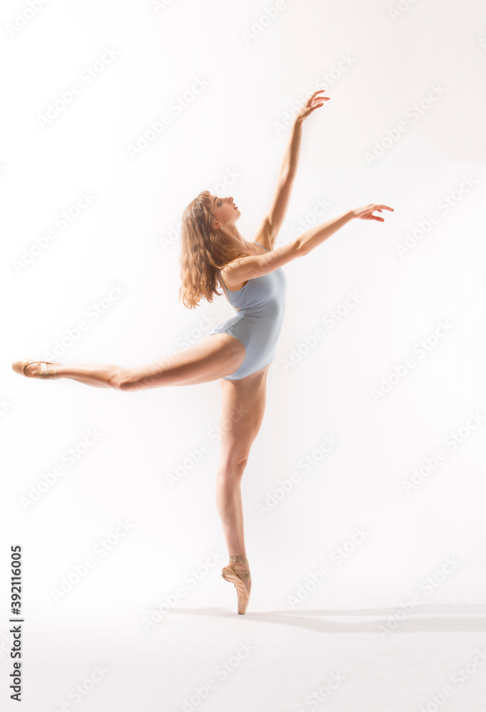 Ballerina in light blue leotard dancing against a white background. Ballerina in light blue leotard dancing against a white background.