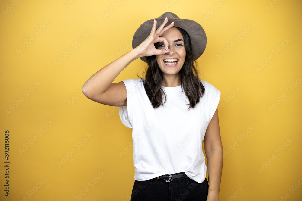 doing ok gesture shocked with smiling face, eye looking through fingers doing ok gesture shocked with smiling face, eye looking through fingers