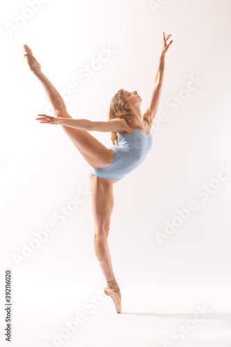 Ballerina in light blue leotard dancing against a white background.