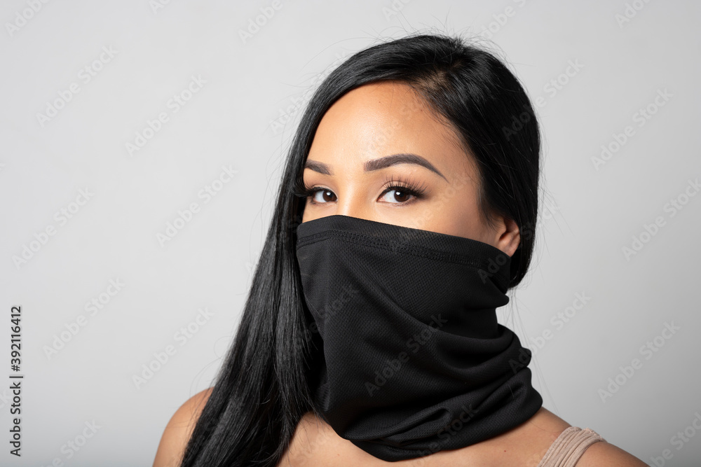 Mixed-Race woman wearing a black gaiter. Studio shot on white. Mixed-Race woman wearing a black gaiter. Studio shot on white.