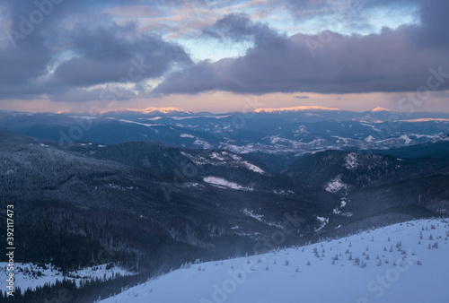 Picturesque winter alps windy day sunrise. Panoramic mountains view from Svydovets ridge and Dragobrat ski resort.