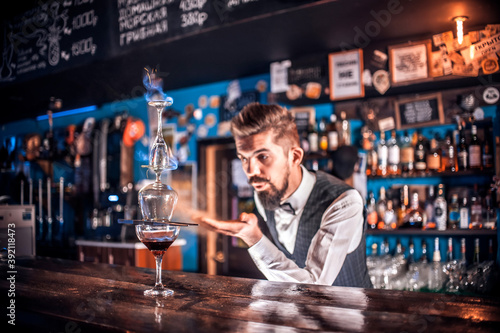 Bearded bartending places the finishing touches on a drink 