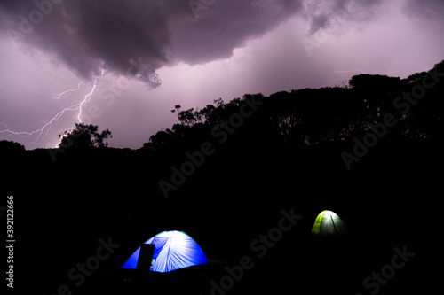 Wild camping under thunderstorm in the mountains. Travelling on road trip and sleep in tents under thunder. Concept about nature, lifestyle and travel. 