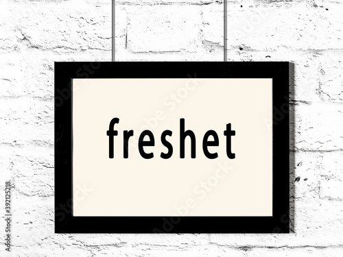 Black frame hanging on white brick wall with inscription freshet