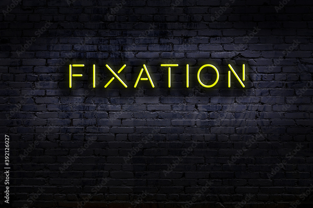 Neon sign. Word fixation against brick wall. Night view Stock