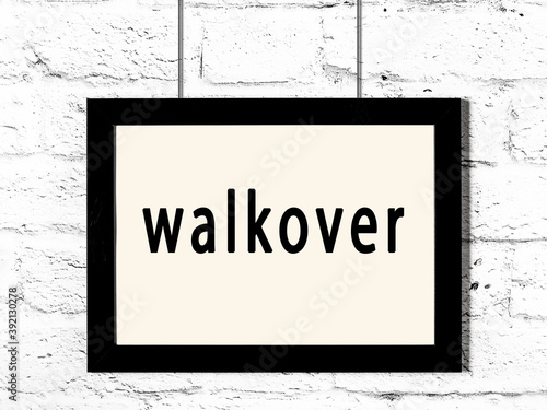 Black frame hanging on white brick wall with inscription walkover