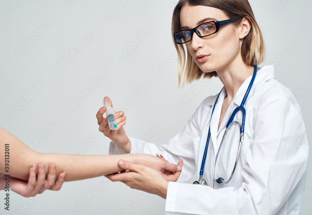 female doctor giving an injection to a scared female patient in a white t-shirt female doctor giving an injection to a scared female patient in a white t-shirt