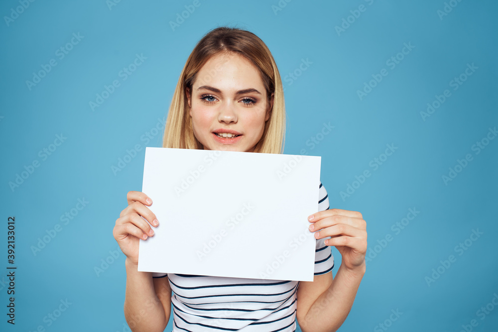 Woman holding sheet of paper striped T-shirt Copy Space cropped view blue background Woman holding sheet of paper striped T-shirt Copy Space cropped view blue background