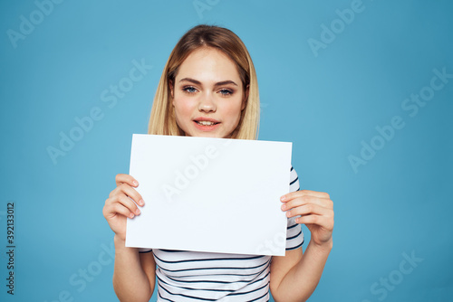 Woman holding sheet of paper striped T-shirt Copy Space cropped view blue background