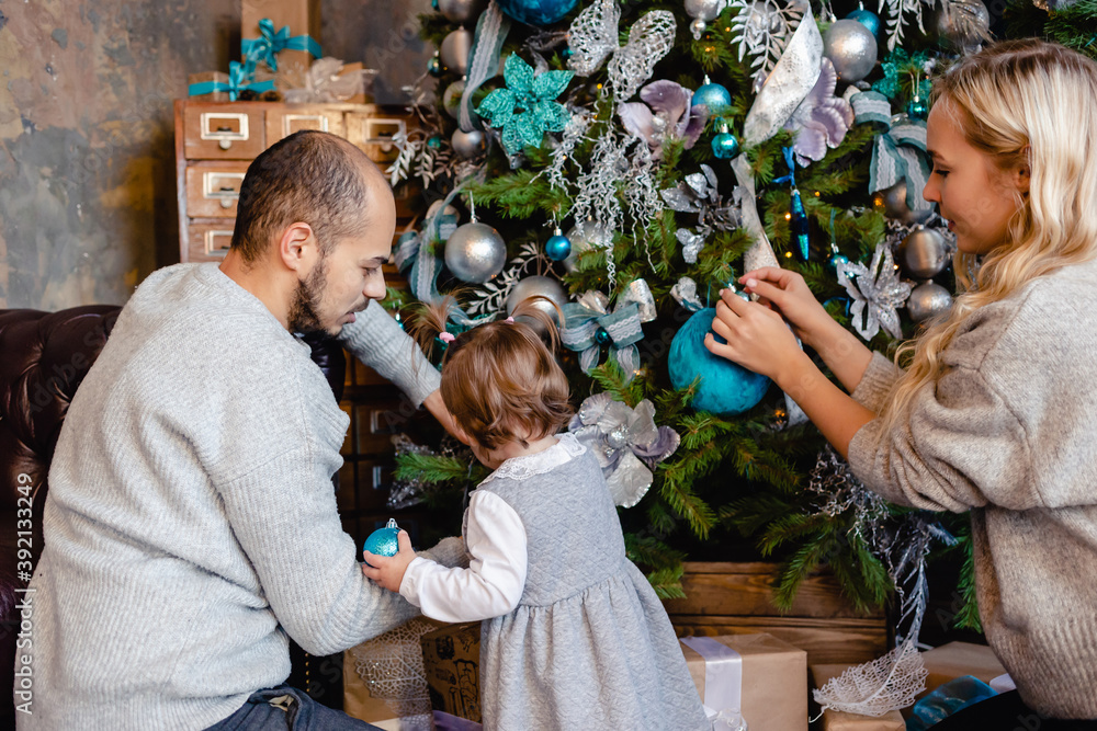 Family with child decorate Christmas tree