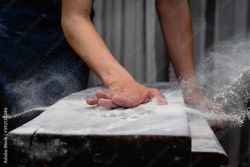 closeup of hand sprinkling flour on table with black background córdoba argentina closeup of hand sprinkling flour on table with black background córdoba argentina