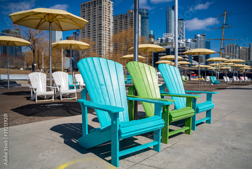 blue and green muskoka chairs in toronto with yellow umbrellas