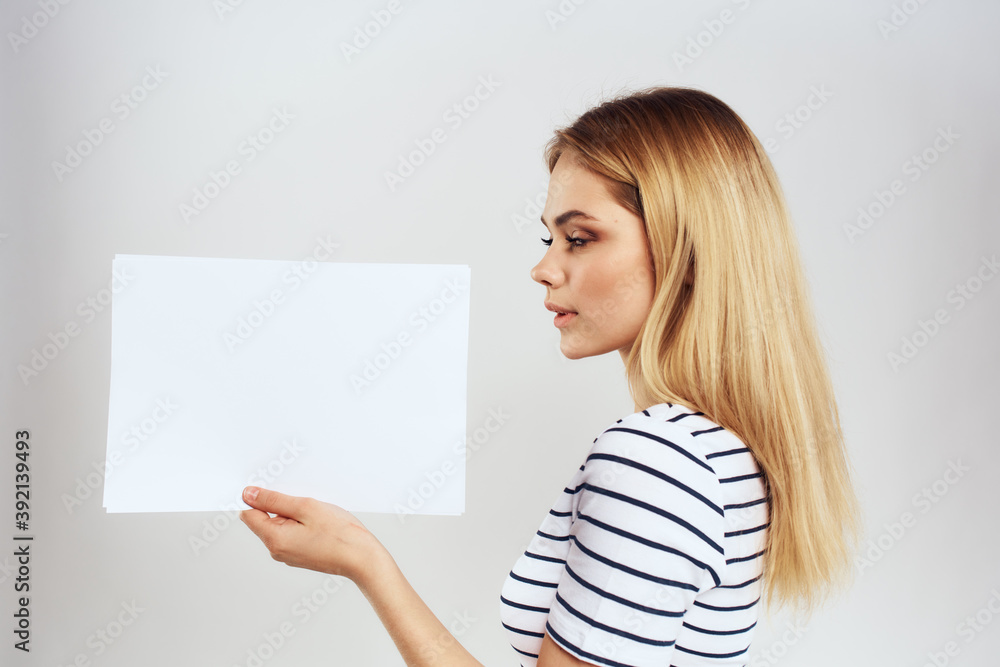 woman holding a sheet of paper in her hands lifestyle striped t-shirt cropped view Copy Space woman holding a sheet of paper in her hands lifestyle striped t-shirt cropped view Copy Space