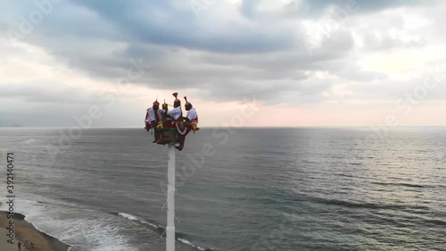 Aerial view of Mexican Papantla Flyers who are ready to perform a rain dance on the beach in Mexico - Panorama View photo