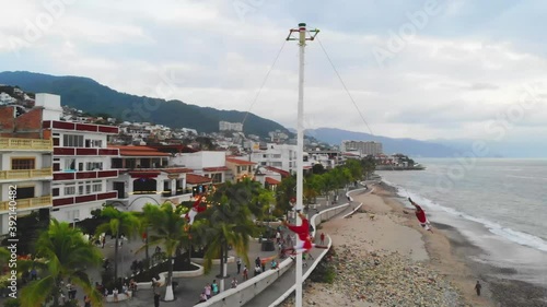 Native Mexican Papantla Flyers are hanging from the pole, dancing their prehispanic rain dance - Panorama view photo