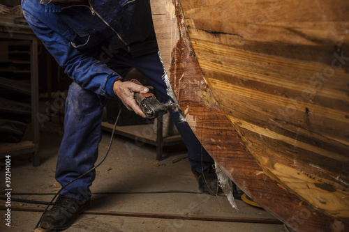 Billede på lærred old man polishing the keel of a traditional boat he is building