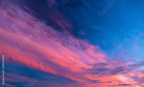 Coral and pink clouds against a blue sky