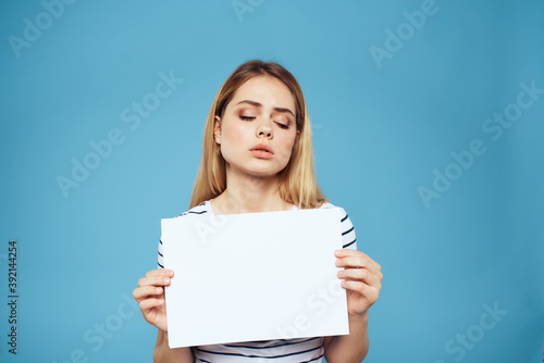 Emotional woman holding a sheet of paper in her hands lifestyle close-up blue background Copy Space