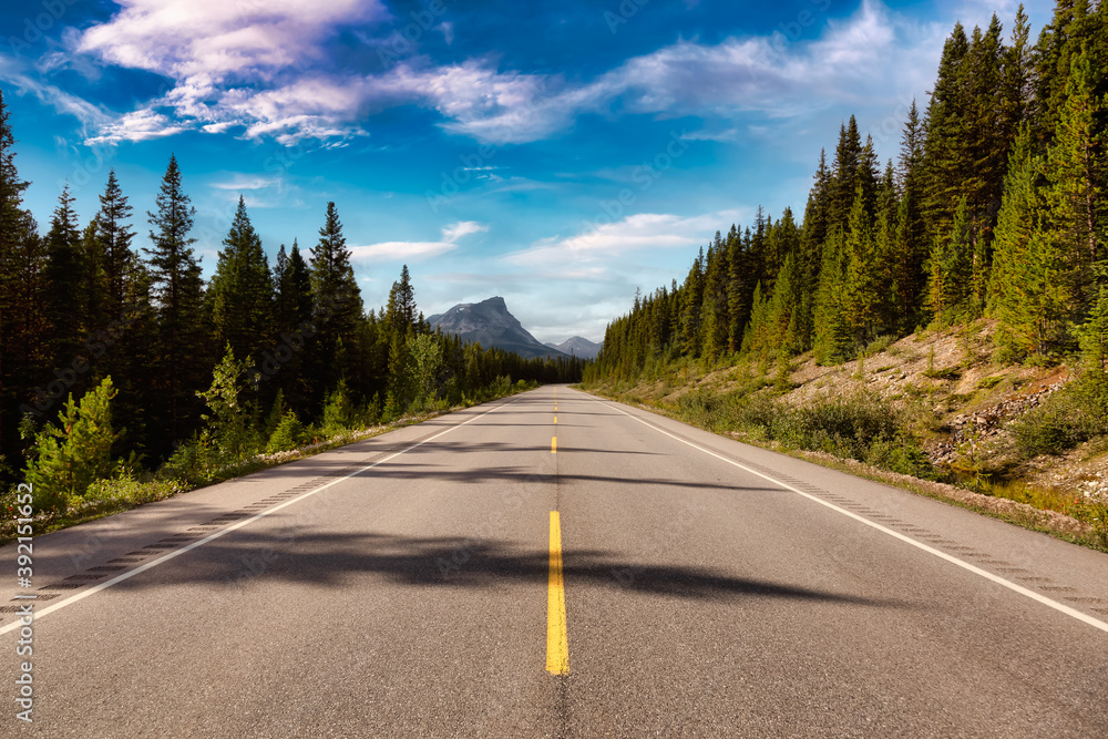 Scenic road in the Canadian Rockies during a vibrant sunny summer day. Taken in Icefields Parkway, Banff National Park, Alberta, Canada.