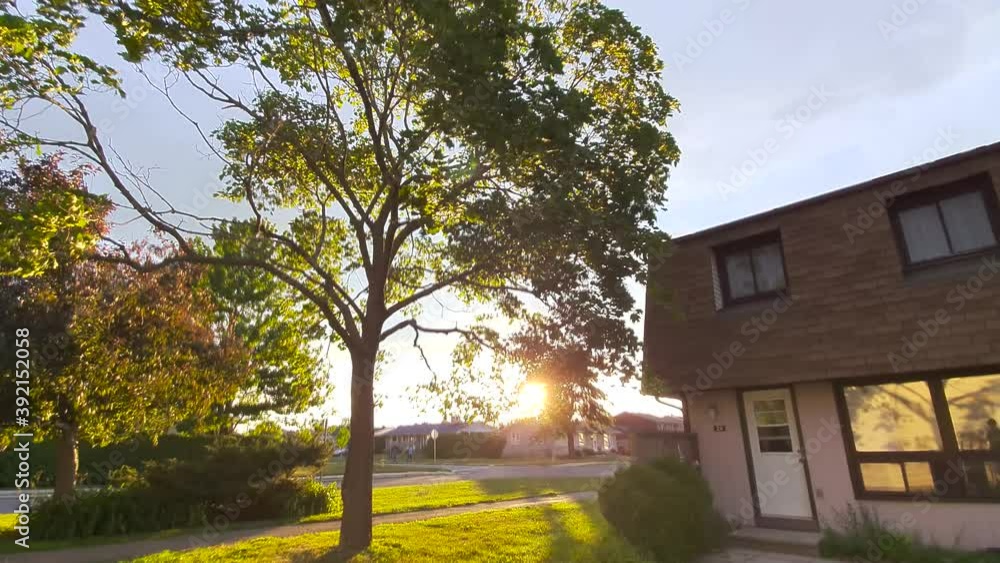 Townhouse on summer day with tree and grass and sun shining through Townhouse on summer day with tree and grass and sun shining through